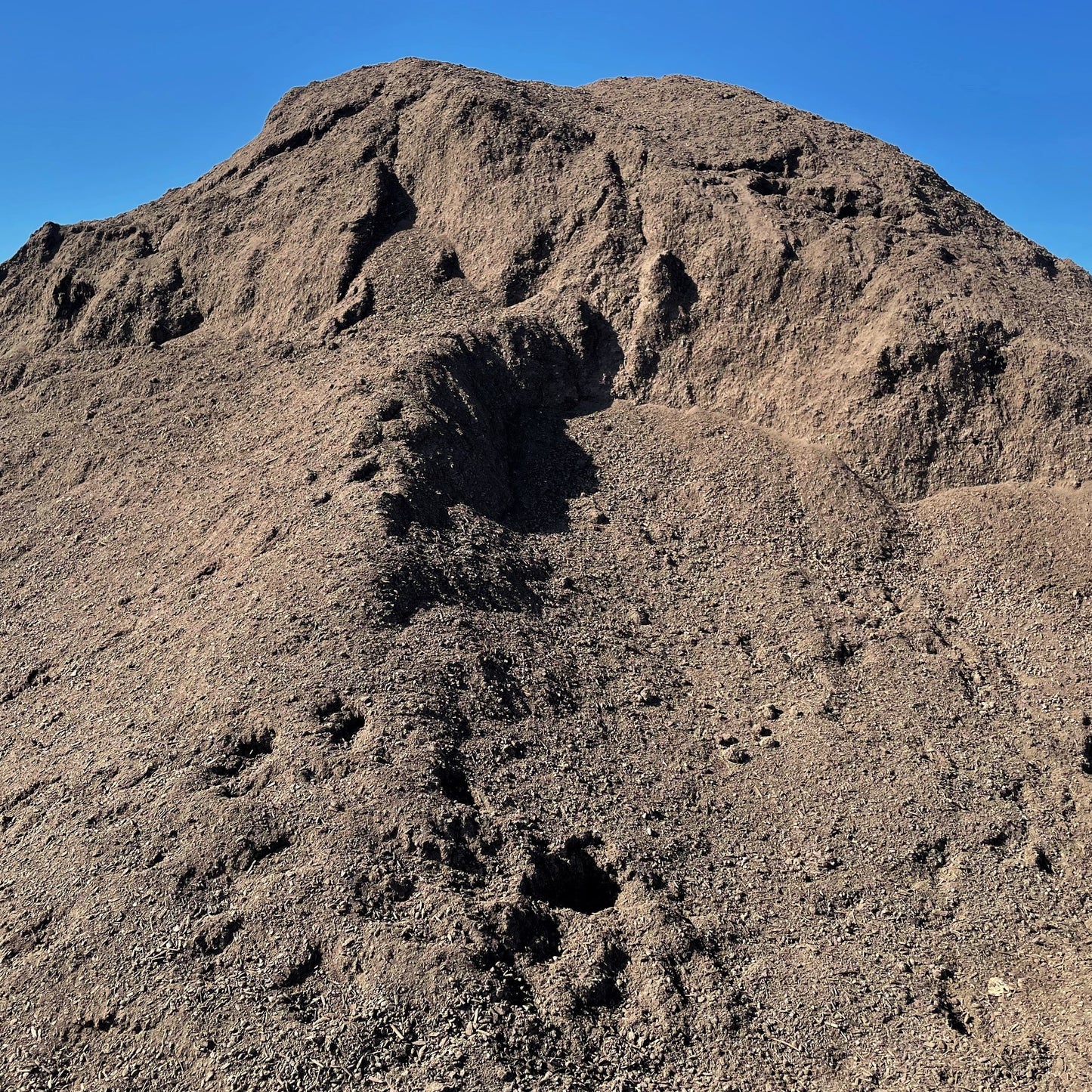 A big pile of Garden City Enriched Topsoil, available for delivery.